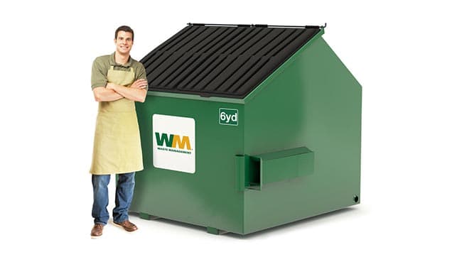 Man stands next to a 6-yard dumpster from Waste Management.