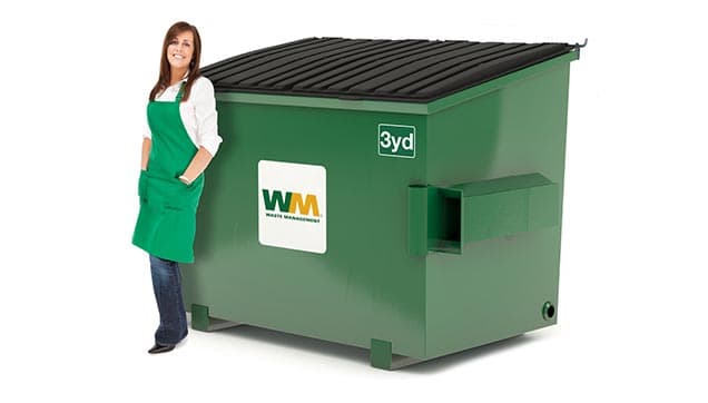 Woman stands next to a 3-yard dumpster from Waste Management.
