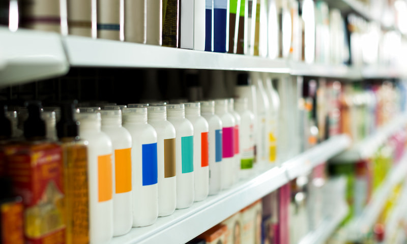 Bottles of cosmetic products sitting on a shelf in a retail store.