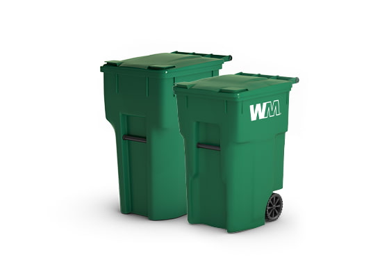 Two matching green plastic trash containers with wheels and handles