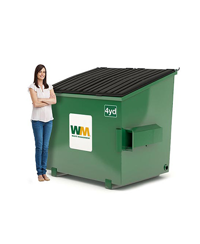 Une femme se tient à côté d'une benne de 4 verges de Waste Management.