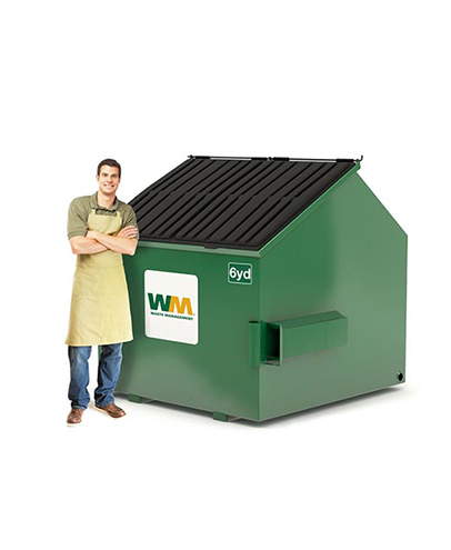 Un homme se tient à côté d'une benne de 6 verges de Waste Management.