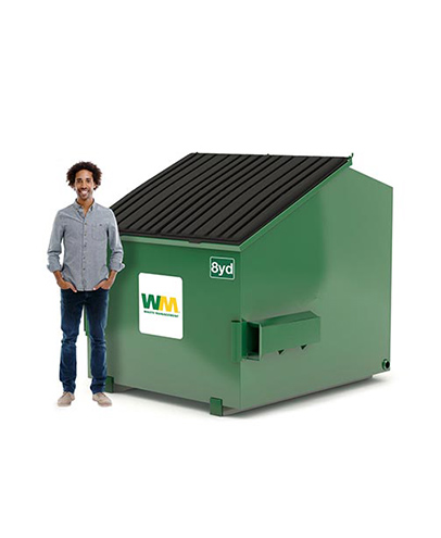 Un homme se tient à côté d'une benne de 8 verges de Waste Management.