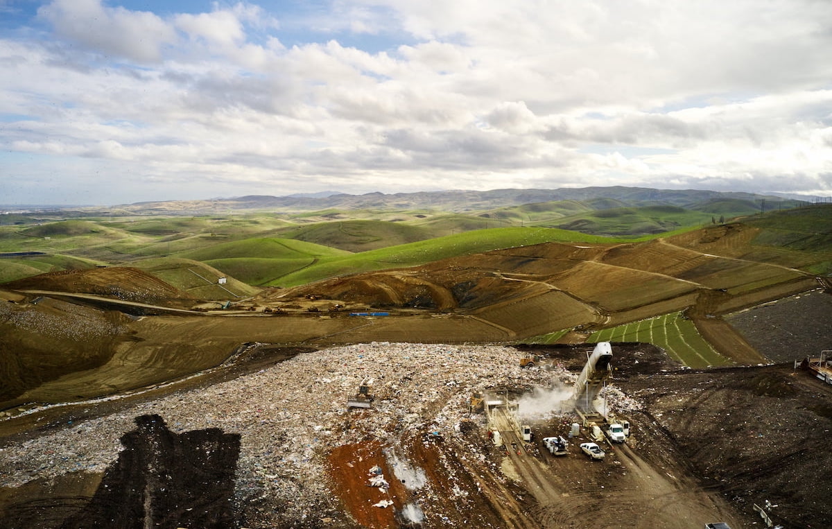 Aerial view of a WM landfill with rolling hills under a prominent view of the sky