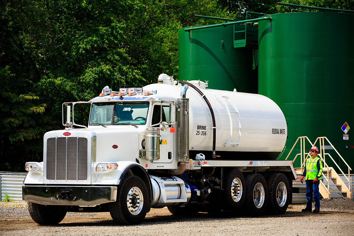 WM tech gives a tanker final check before it departs for an environmental waste disposal job