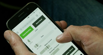 Close-up view of a person using WM's CONNECTED LANDFILL® system on their mobile phone.