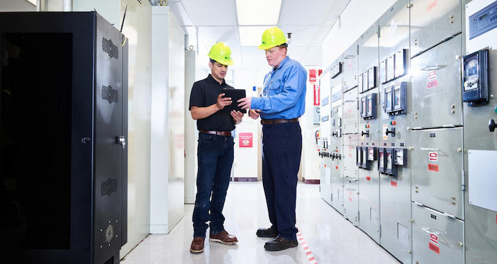 Two technicians review a tablet to resolve a technical issue at a WM landfill.
