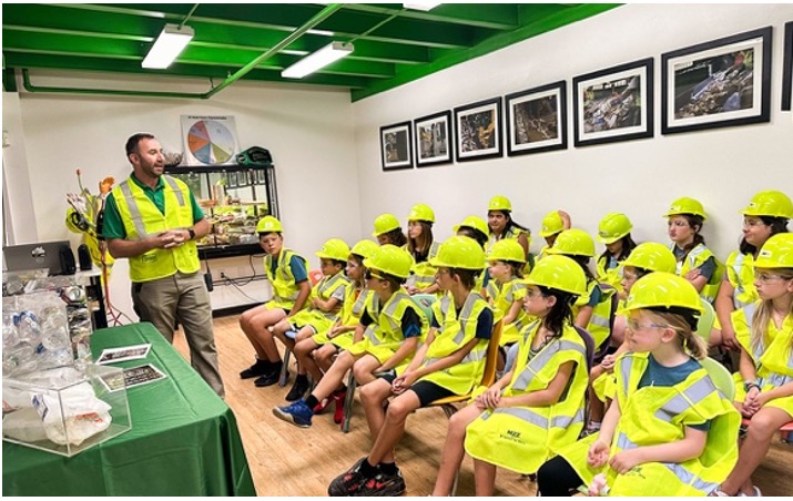 An employee educates children about recycling at WM River Hills Materials Recovery Facility