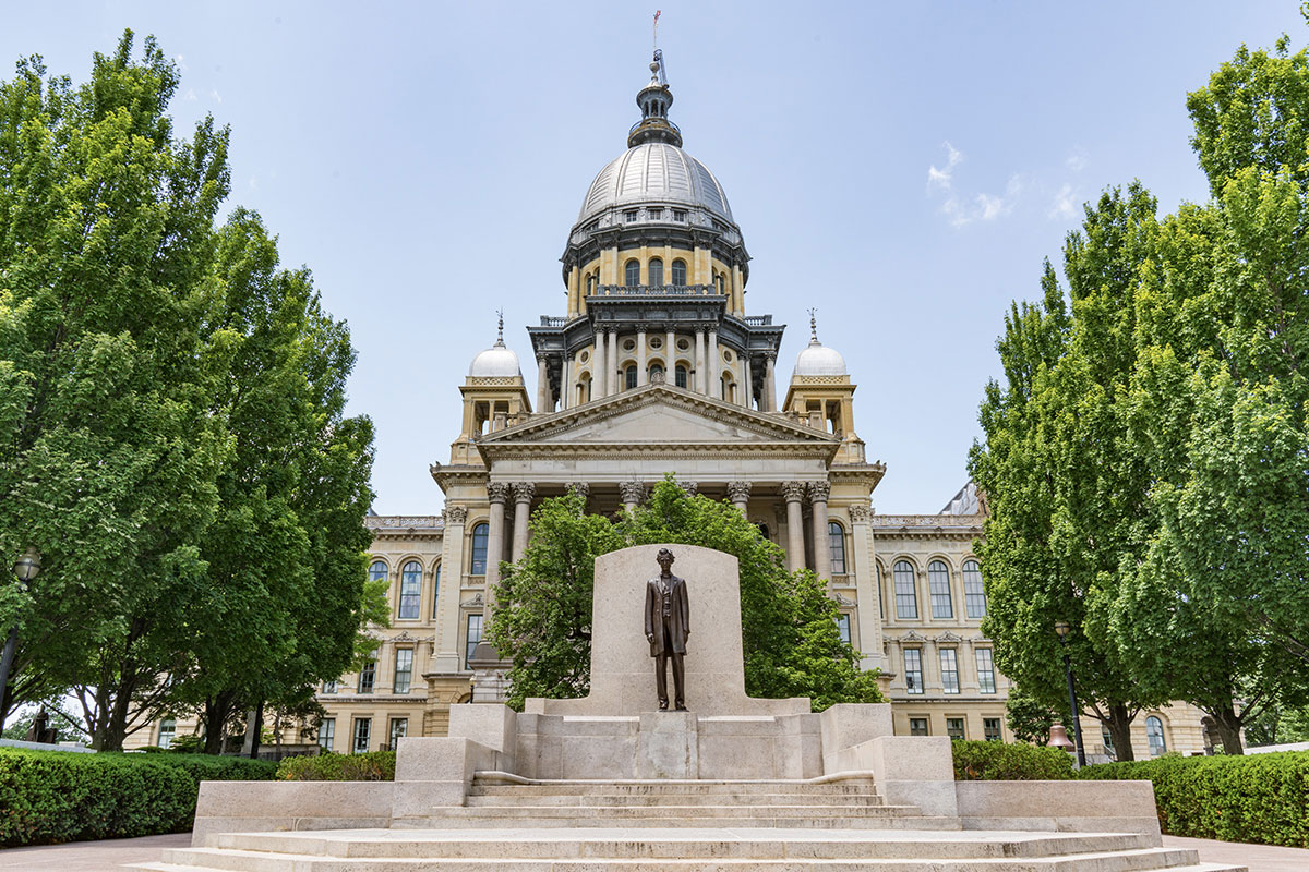 Front statue, greenery, and steps leading into the dome of the Louisville capitol building