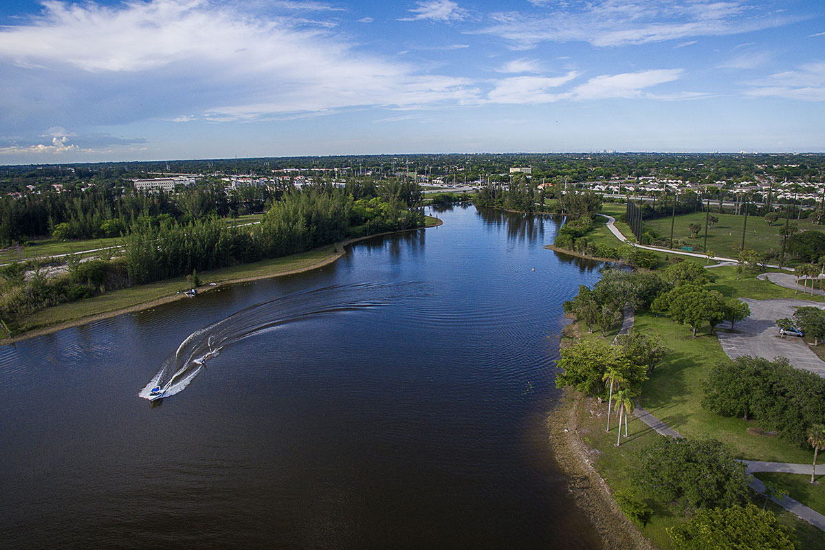 Small speed boat passing through river inside Florida community